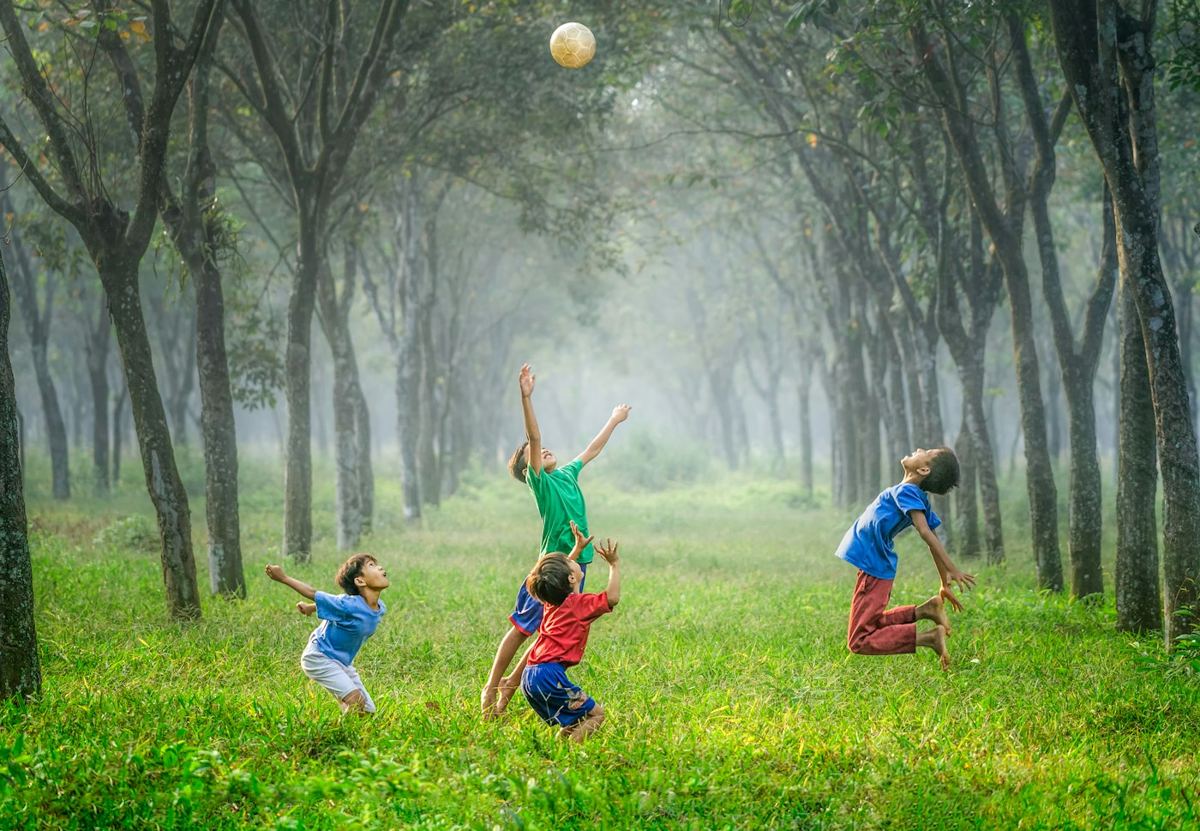 芝生の上でボール遊びをする子どもたち