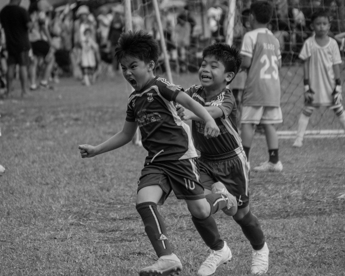 サッカーの試合でボールを競り合う子どもたち